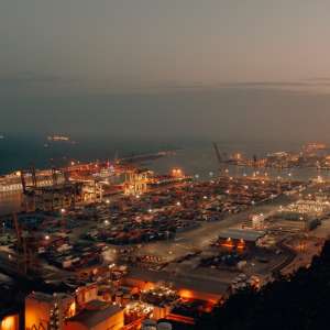 distant-shot-port-with-boats-loaded-with-cargo-shipment-during-nighttime